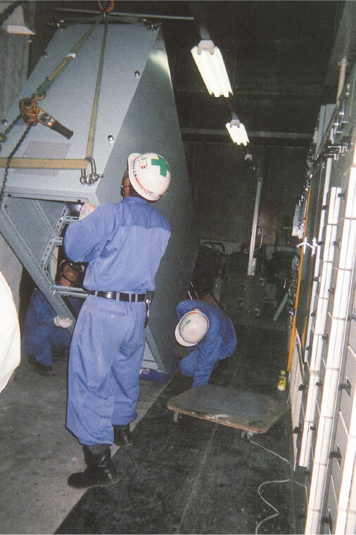 写真：社員が電気盤を搬入している様子