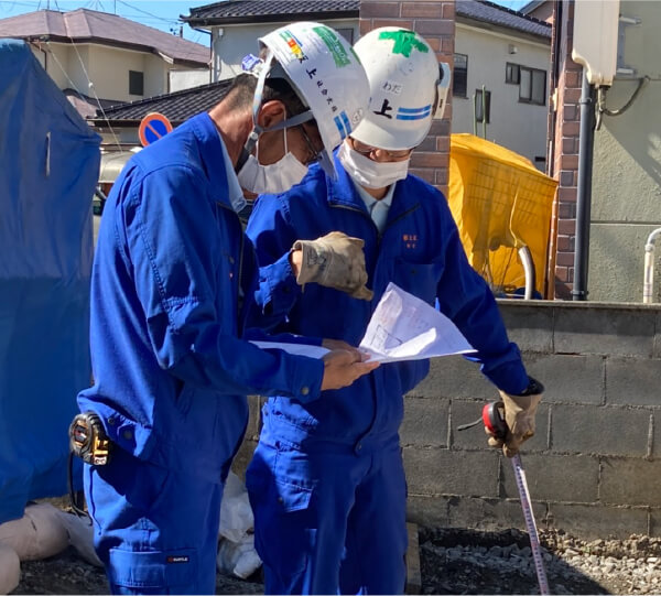 写真:新入社員が先輩に仕事方法を習っている様子